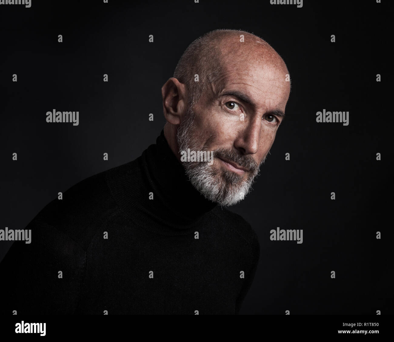 Studio portrait on black background of a mature man. Stock Photo