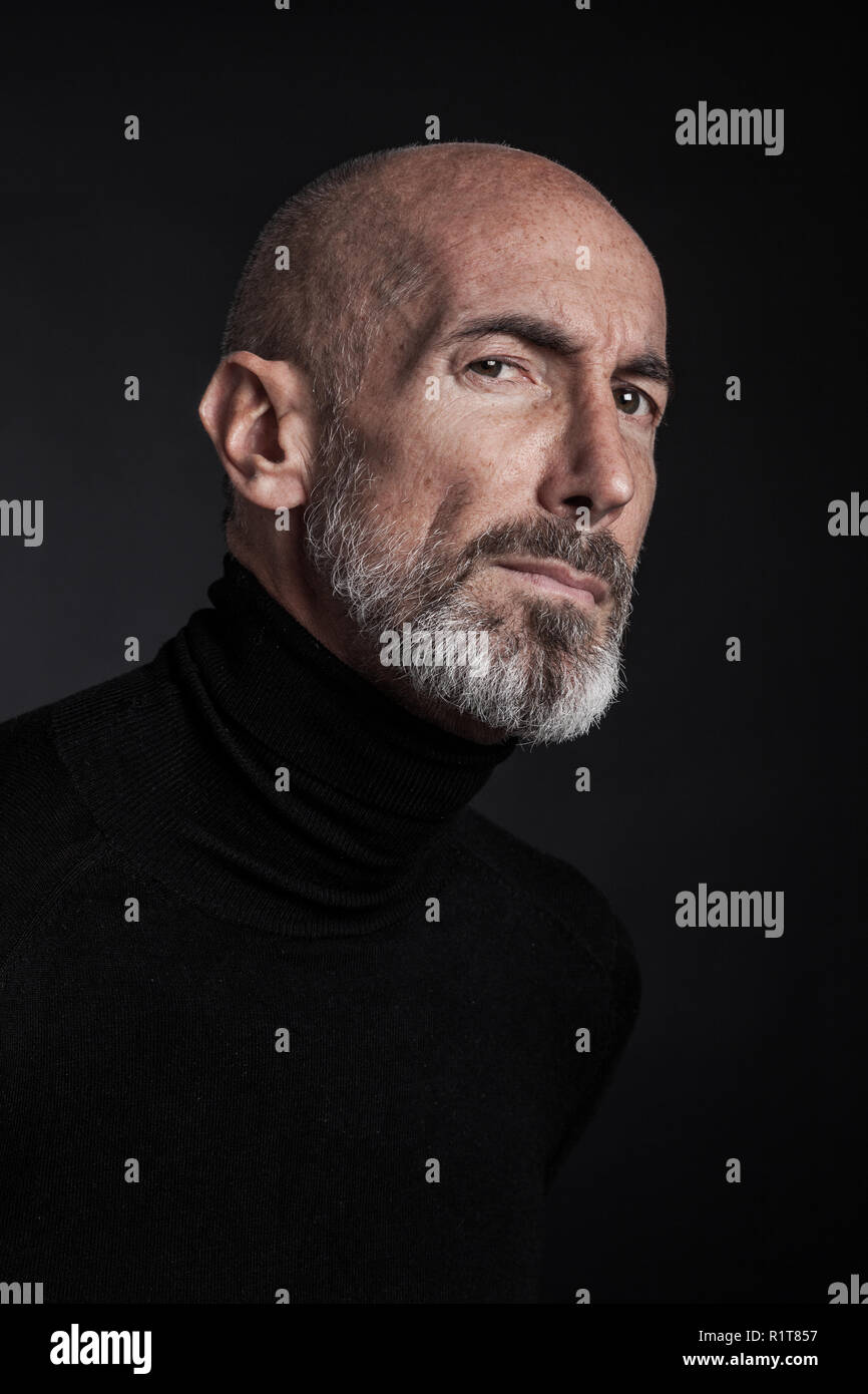 Studio portrait on black background of a mature man. Stock Photo