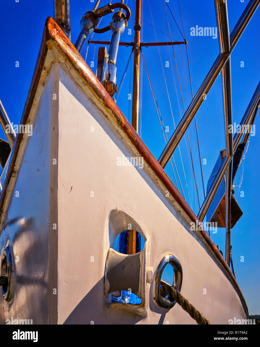 Boat bow from sailboat under blue sky with anchor chain and winch