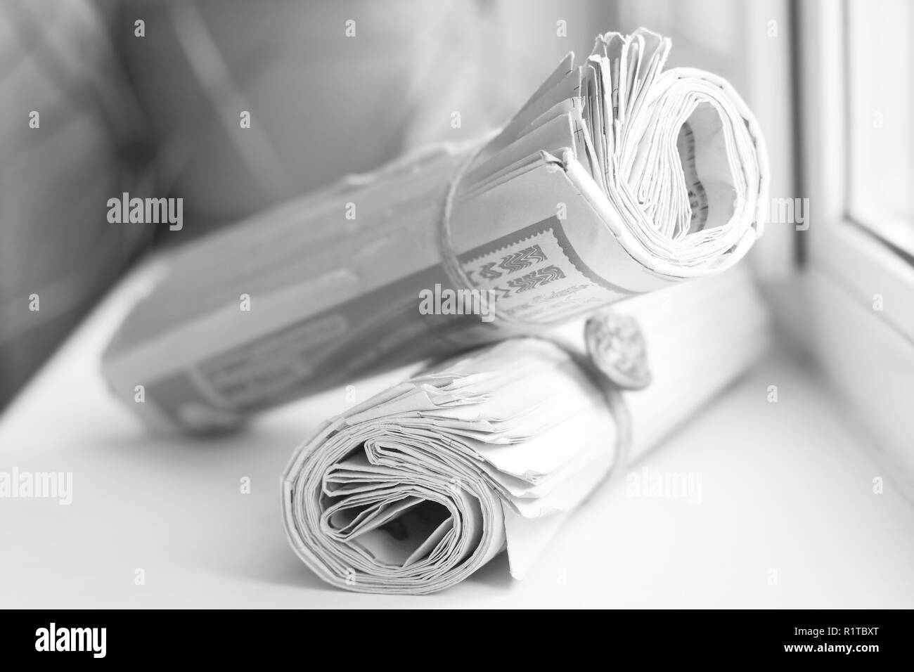 Two rolled newspapers with headlines and articles, concept for business news Stock Photo