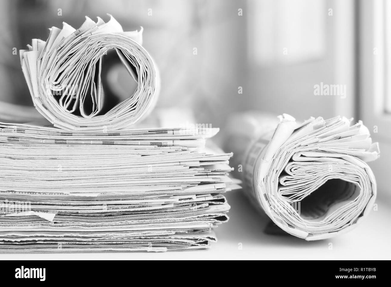 Pile of fresh morning newspapers on the table at office. Latest financial and business news in daily paper. Pages with information headlines, articles Stock Photo