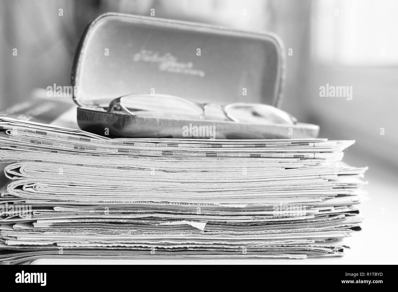 Big pile of newspapers and reading glasses in leather case, business concept Stock Photo
