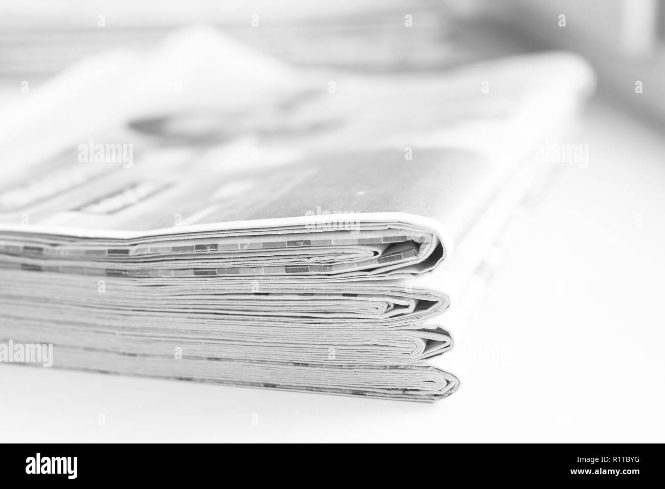Pile of fresh morning newspapers on the table at office. Latest financial and business news in daily paper. Pages with information headlines, articles Stock Photo