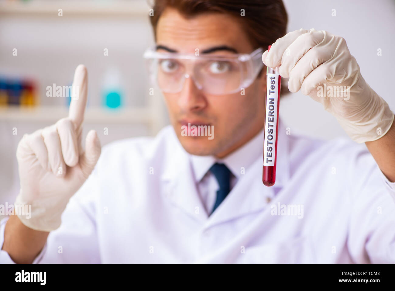 Young handsome lab assistant testing blood samples in hospital Stock