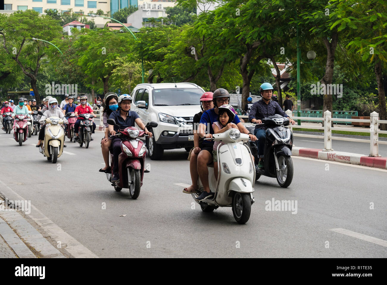 Street scene with people riding motorbikes and scooters on a busy city road. Hanoi, Vietnam, Asia Stock Photo
