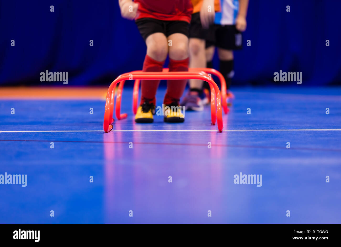 Futsal jumping drills. Futsal indoor soccer training session. Young futsal players exercising for agility and coordination Stock Photo