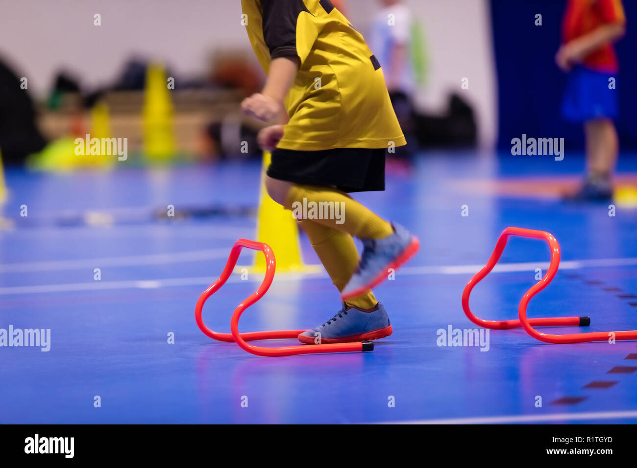 Children training futsal jumping drills. Futsal indoor soccer training session. Kids futsal players exercising for agility and coordination Stock Photo