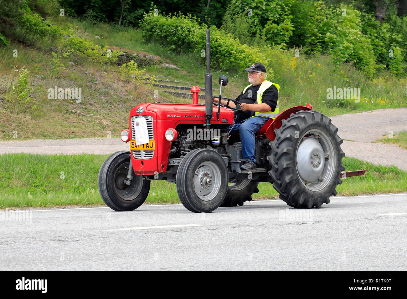 Classic Massey-Ferguson 35 tractor and driver on Kimito Tractorkavalkad, Tractor Cavalcade, an annual tractor show in Kimito, Finland - July 7, 2018. Stock Photo