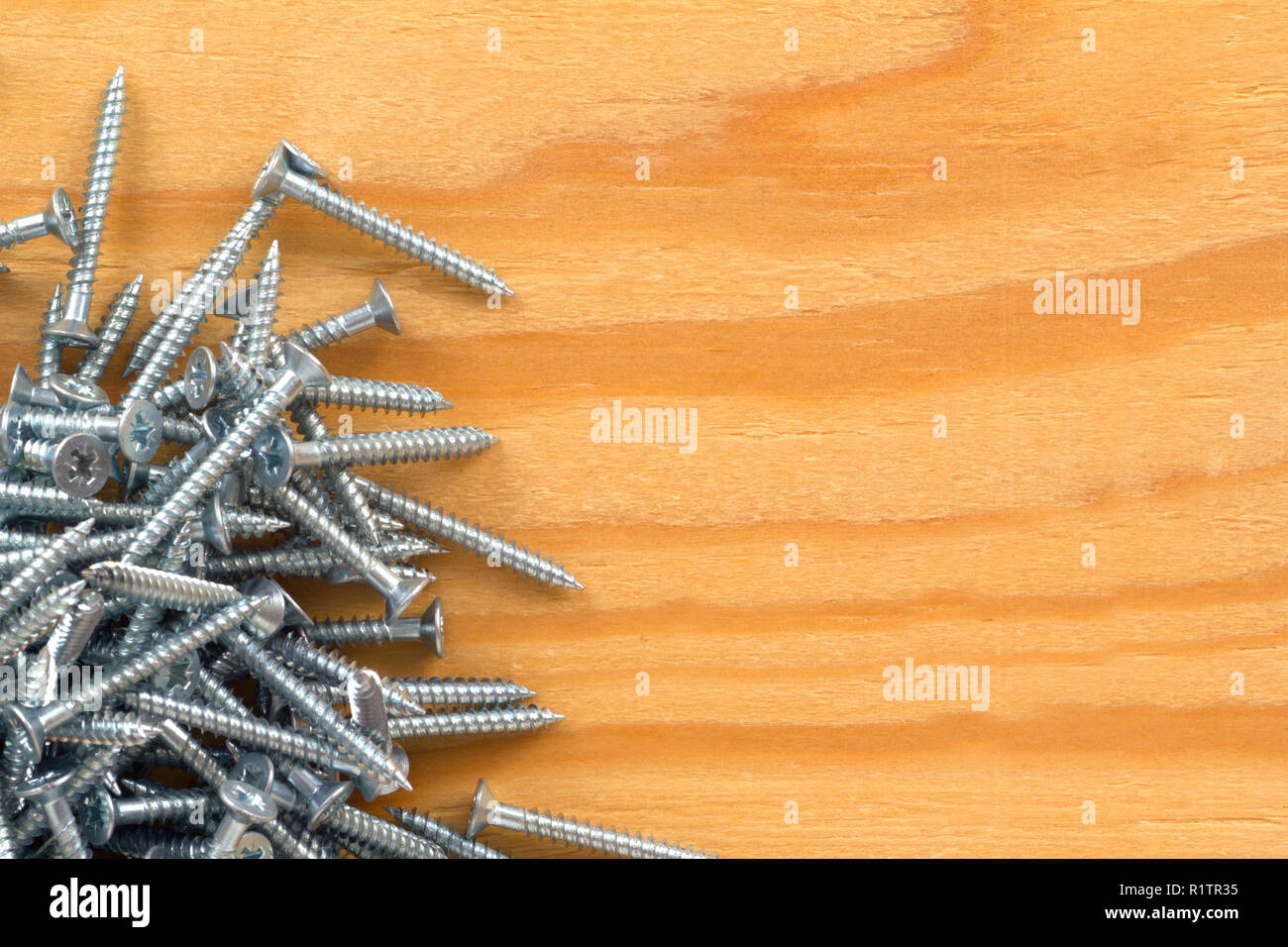 Cross head wood screws on a pine board with copy space Stock Photo