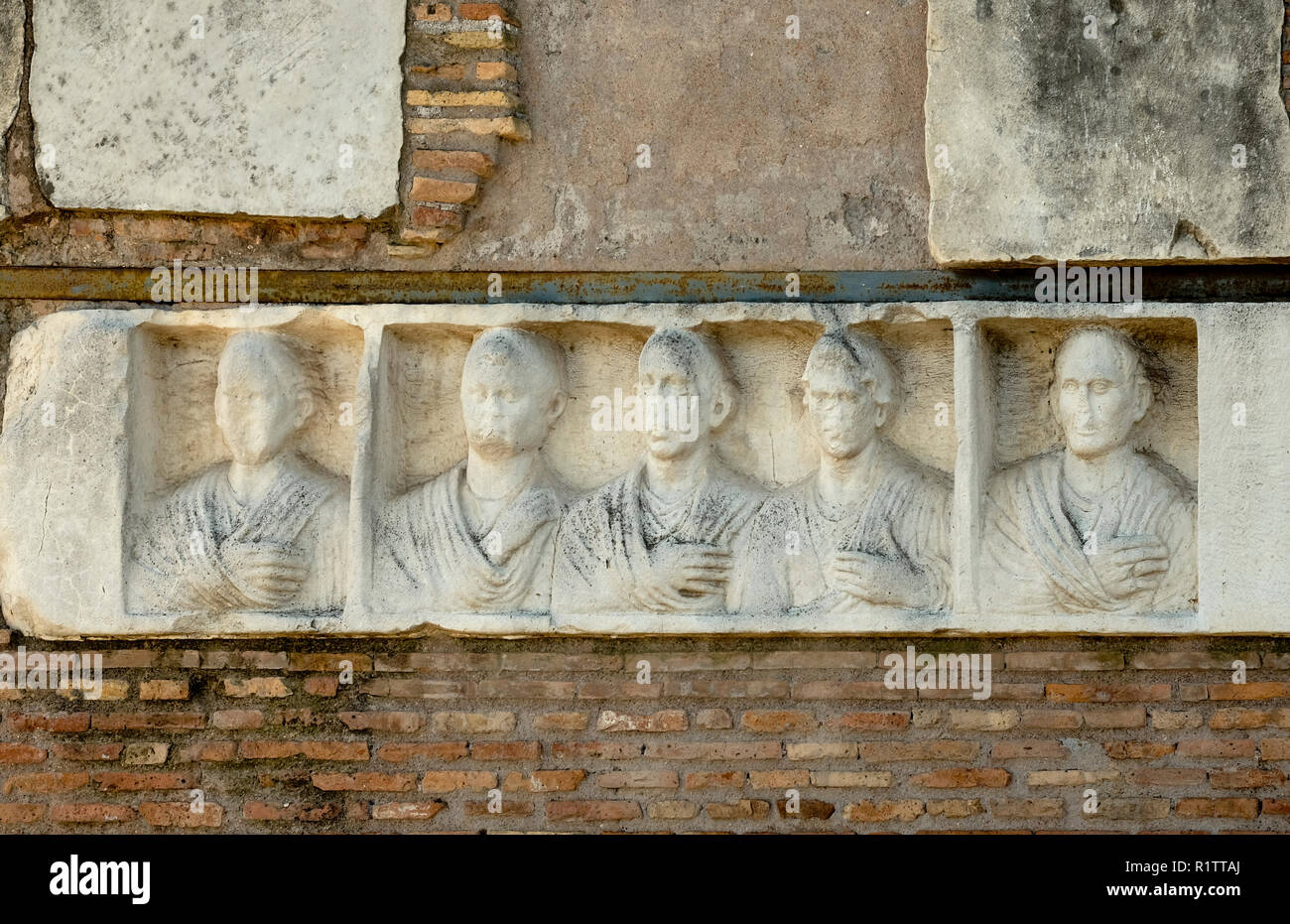 In the Ilario Fusco's tomb on the Appia Antica in Rome, there is a relief with five portraits of deads. Stock Photo