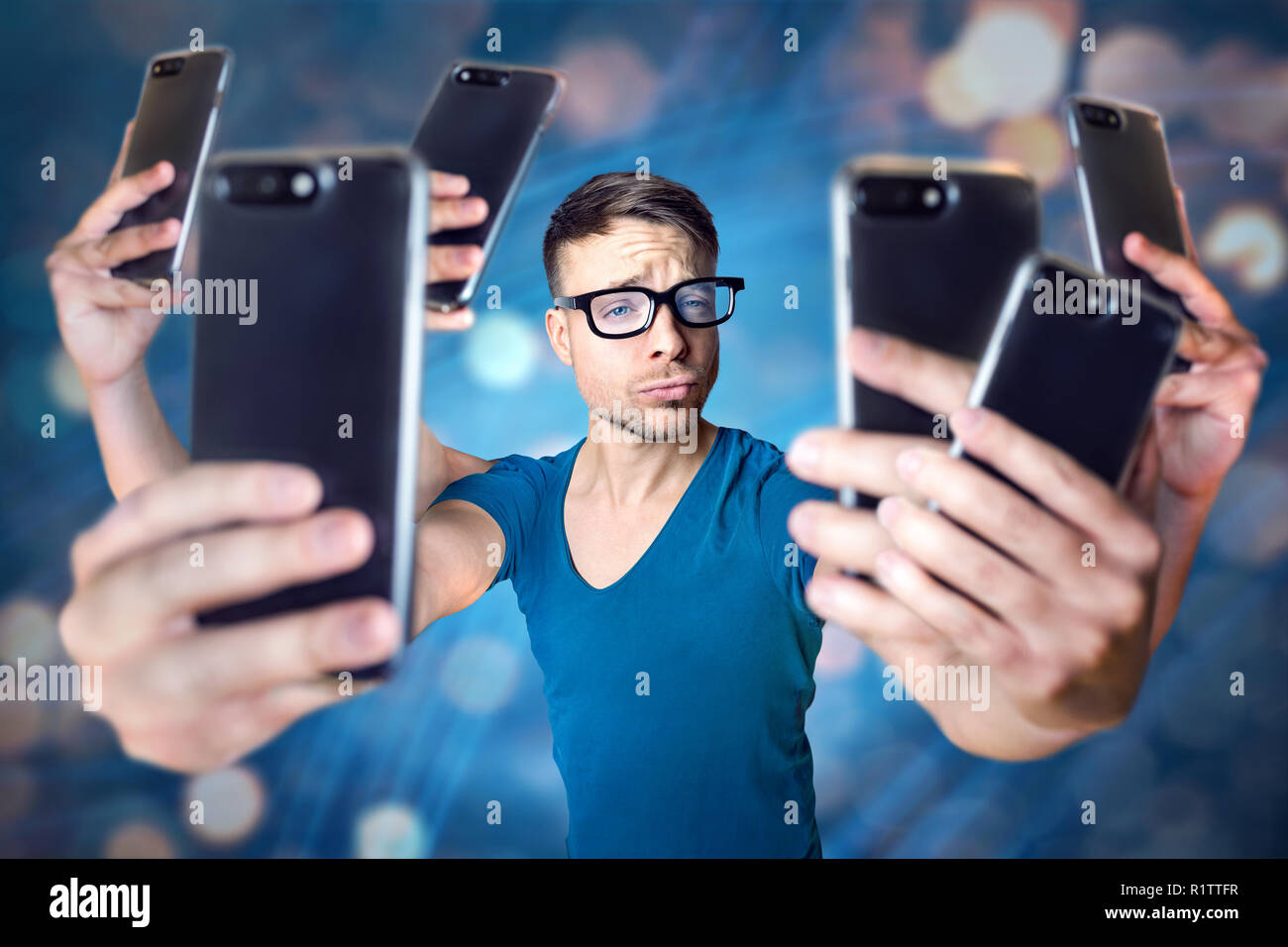 Influencer holding an exaggerated number of smartphones Stock Photo