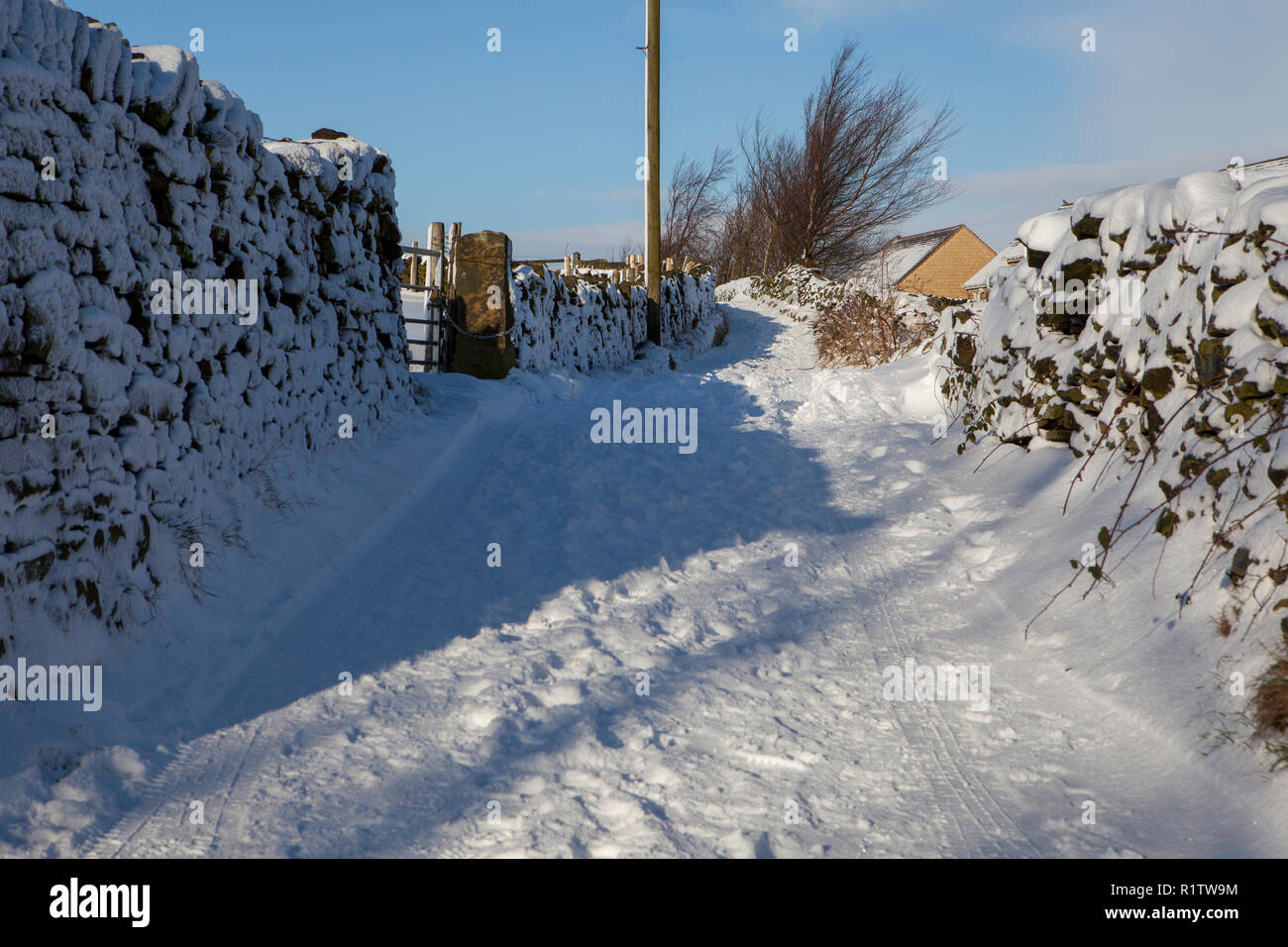 Winter view of a historic walled lane near Meltham in West Yorkshire after snow Stock Photo