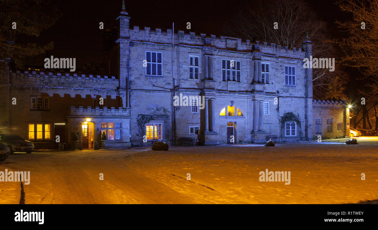 View of the illuminated facade of Malton Lodge Hotel taken at night in winter after snow Stock Photo