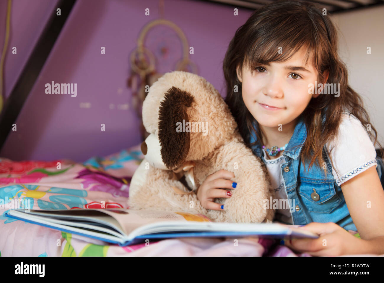 A 7 years old girl reading a book on bed Stock Photo Alamy