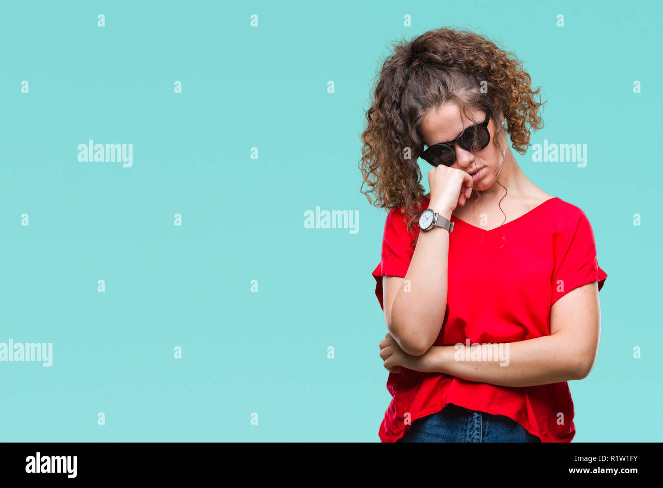Beautiful curly hair young girl wearing sunglasses over