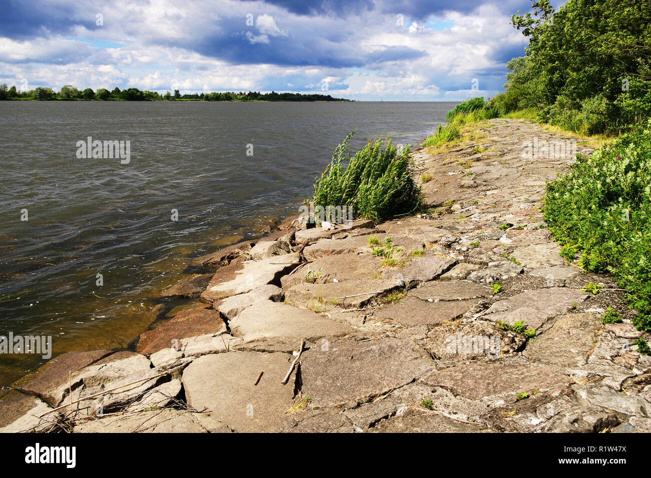 The mouth of the Vistula River to the Baltic Sea with a stone river embankment on a sunny day. Pomerania, Poland. Stock Photo