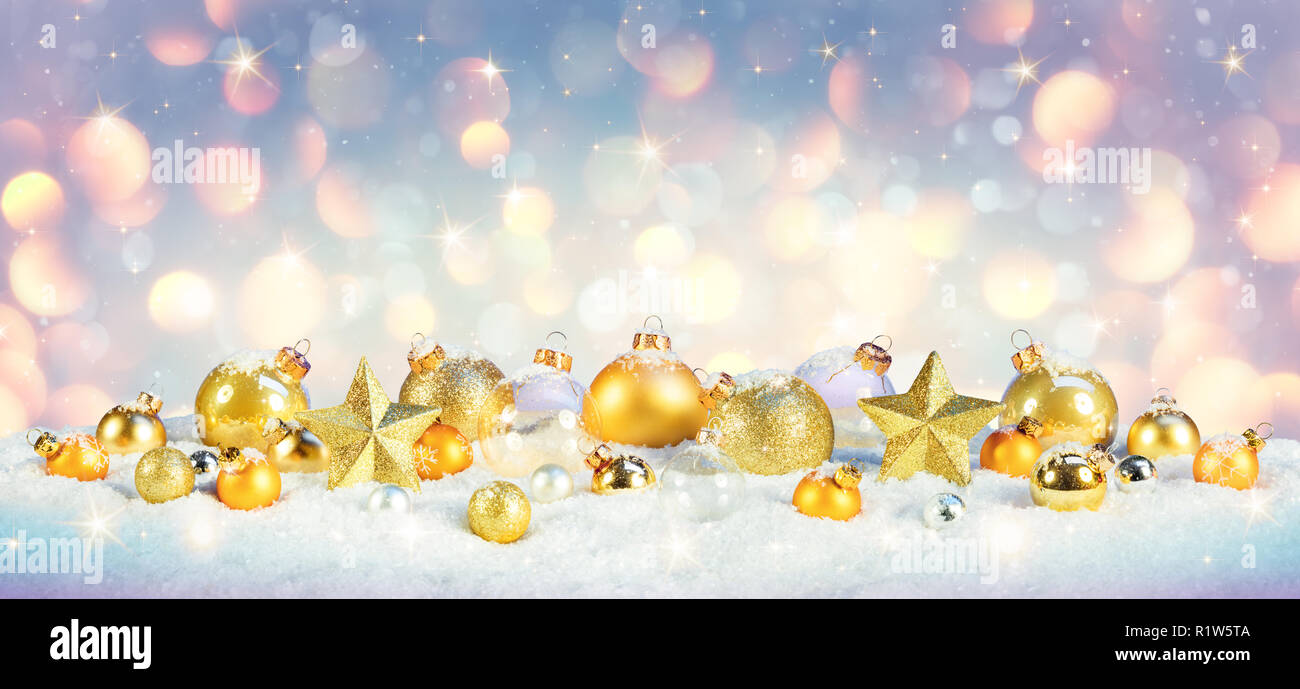 Christmas - Golden Baubles On Snow With Shiny Background Stock Photo