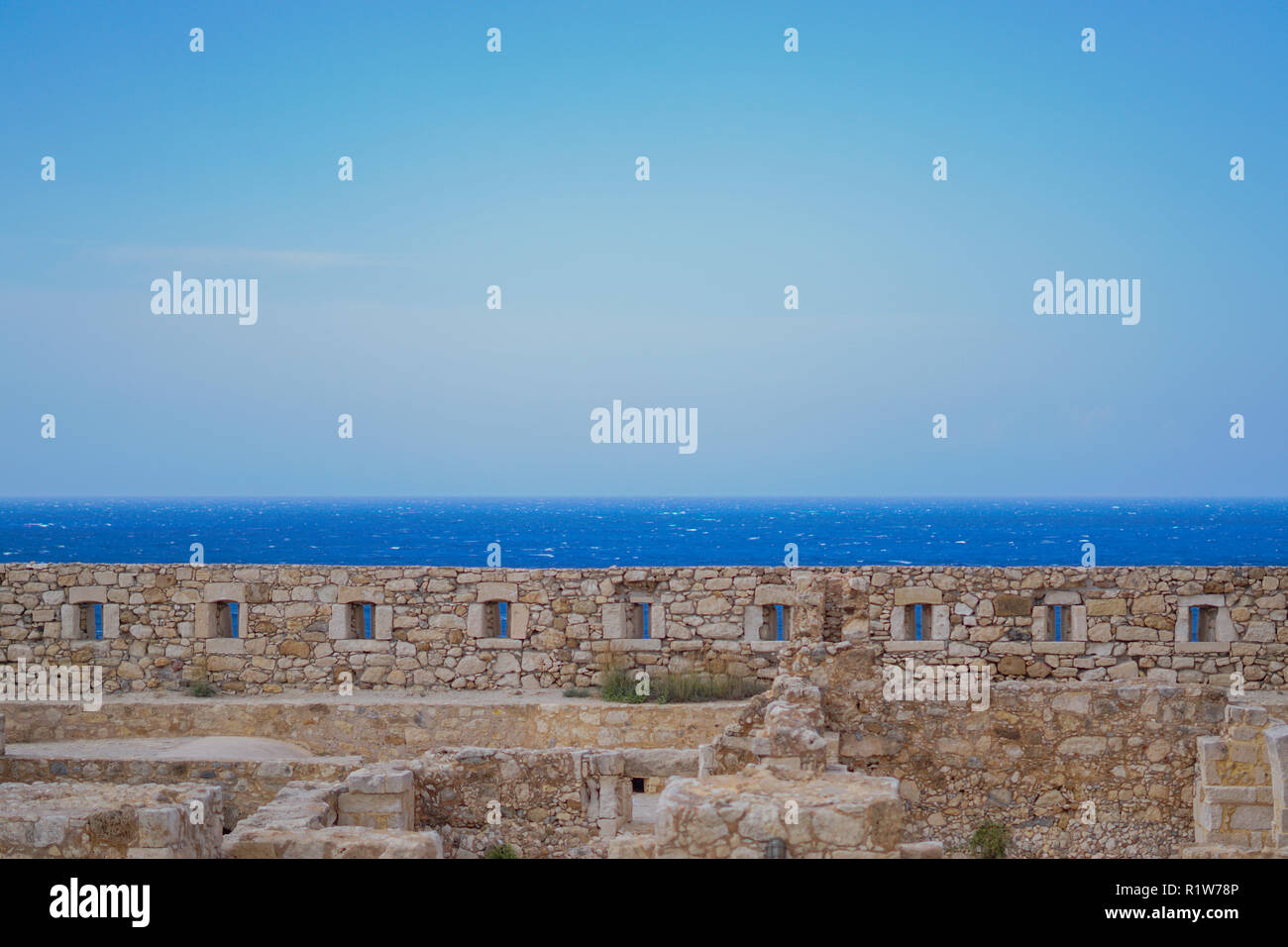 Windows in limestone wall of Fortezza of Rethimno, overlooking the sea. Rethimno, Crete. Stock Photo