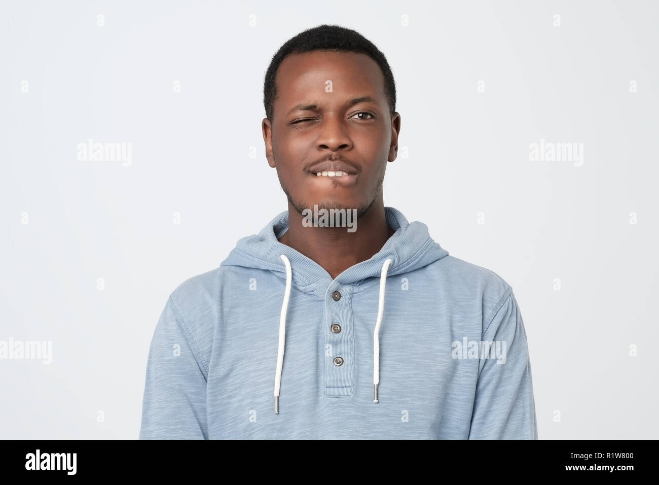 Funny african man blinking his eye looking at camera Stock Photo Alamy