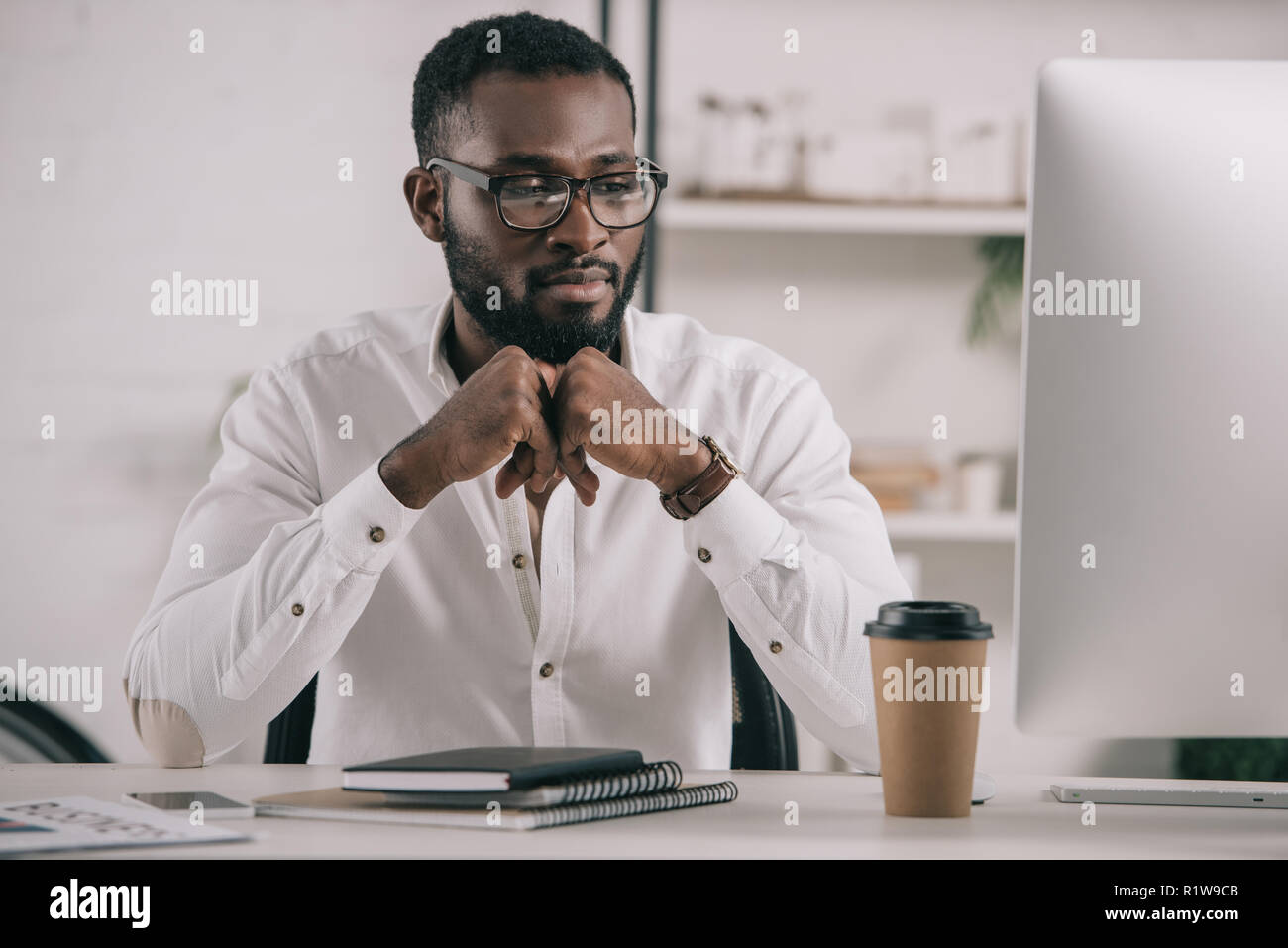 handsome african american businessman looking at computer in office Stock Photo