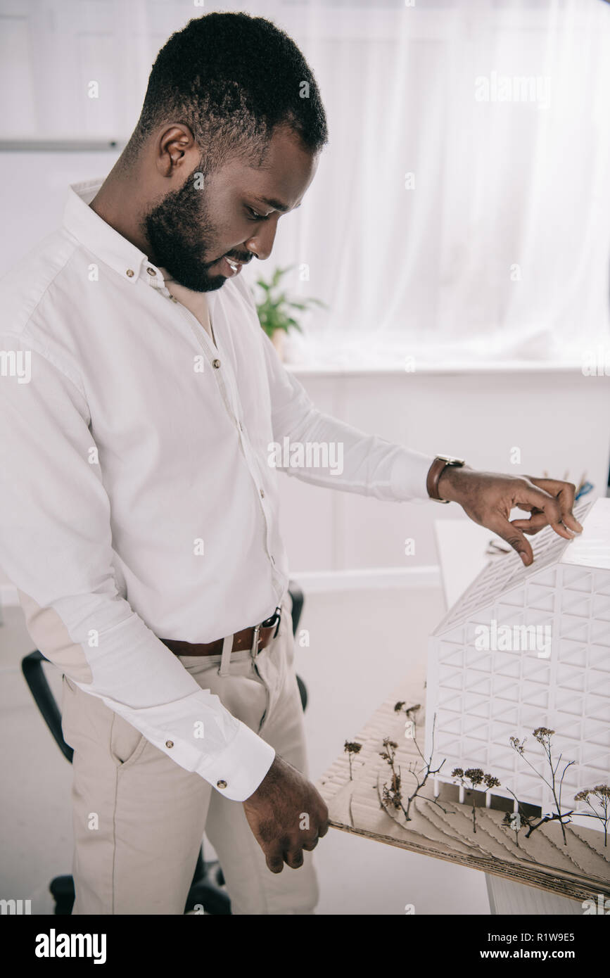 side view of handsome african american architect working on architecture model in office Stock Photo