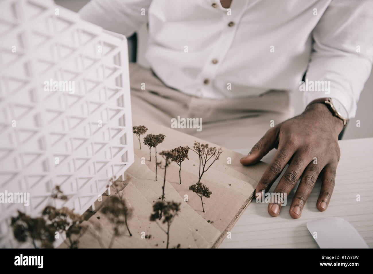 cropped image of african american architect sitting near architecture model on table in office Stock Photo