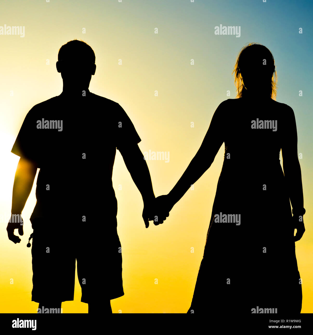couple silhouette in front of a sunset Stock Photo - Alamy