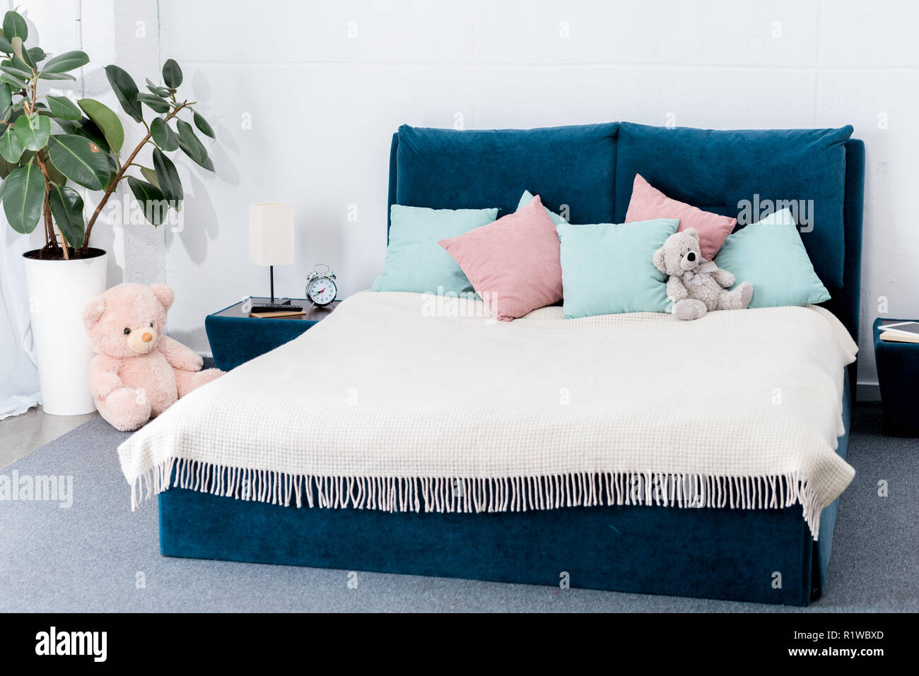 interior of bedroom with pink and blue pillows and teddy bears Stock