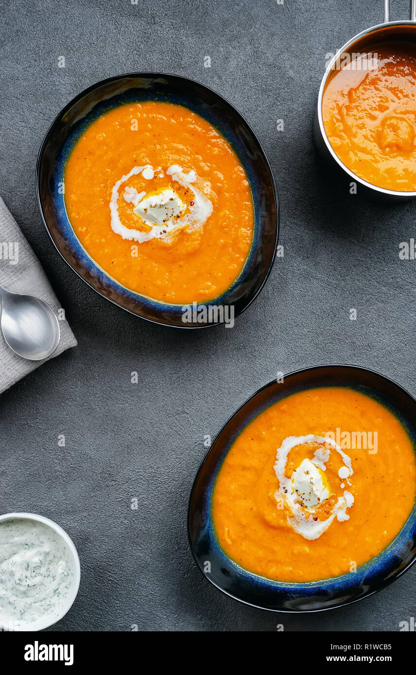Top view of pumpkin soup in two plates plate and pot Stock Photo