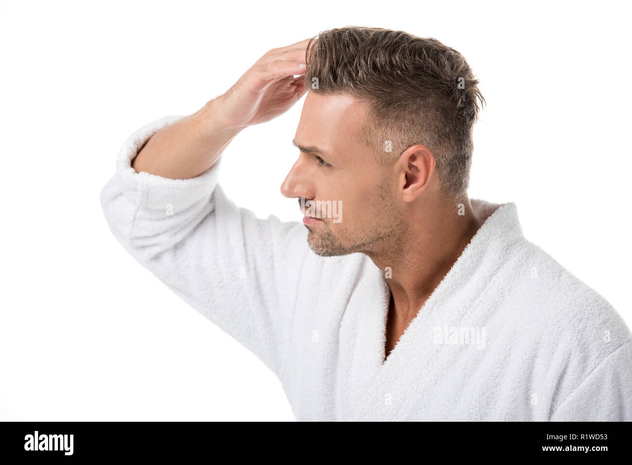 Side View Of Upset Adult Man In Bathrobe Checking Himself For Hair