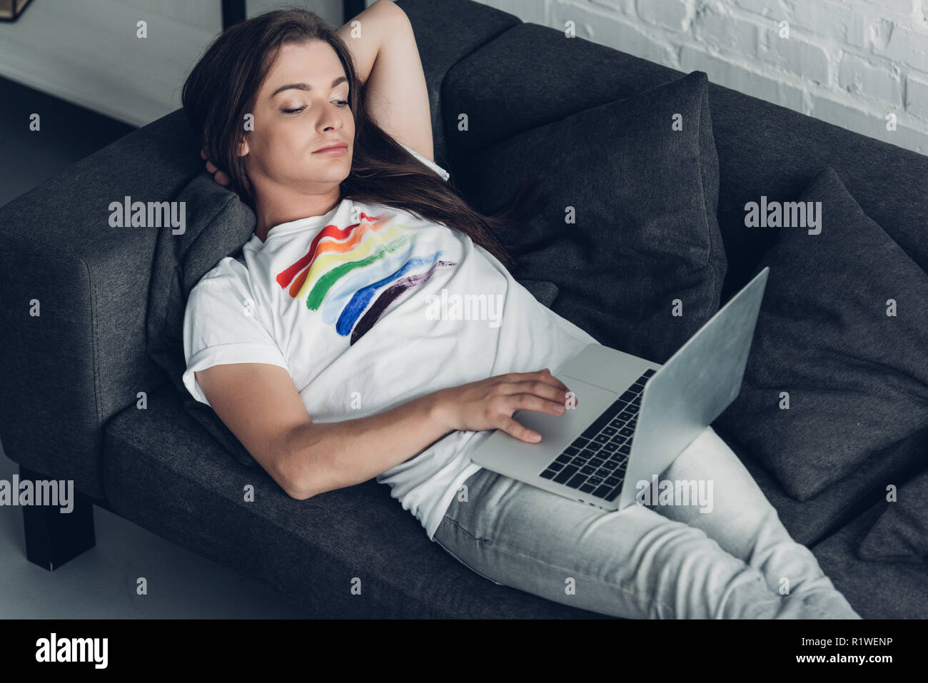 Relaxed Young Transgender Freelancer Man Working With Laptop On