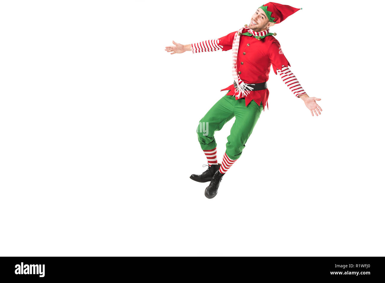 happy man in christmas elf costume jumping isolated on white background Stock Photo
