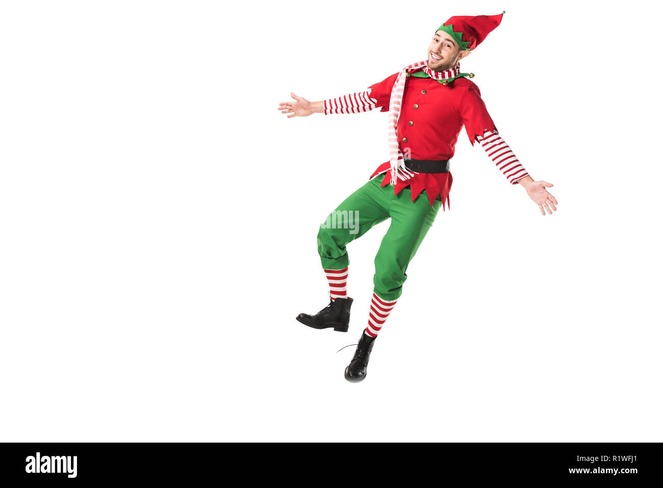 cheerful man in christmas elf costume jumping isolated on white background Stock Photo