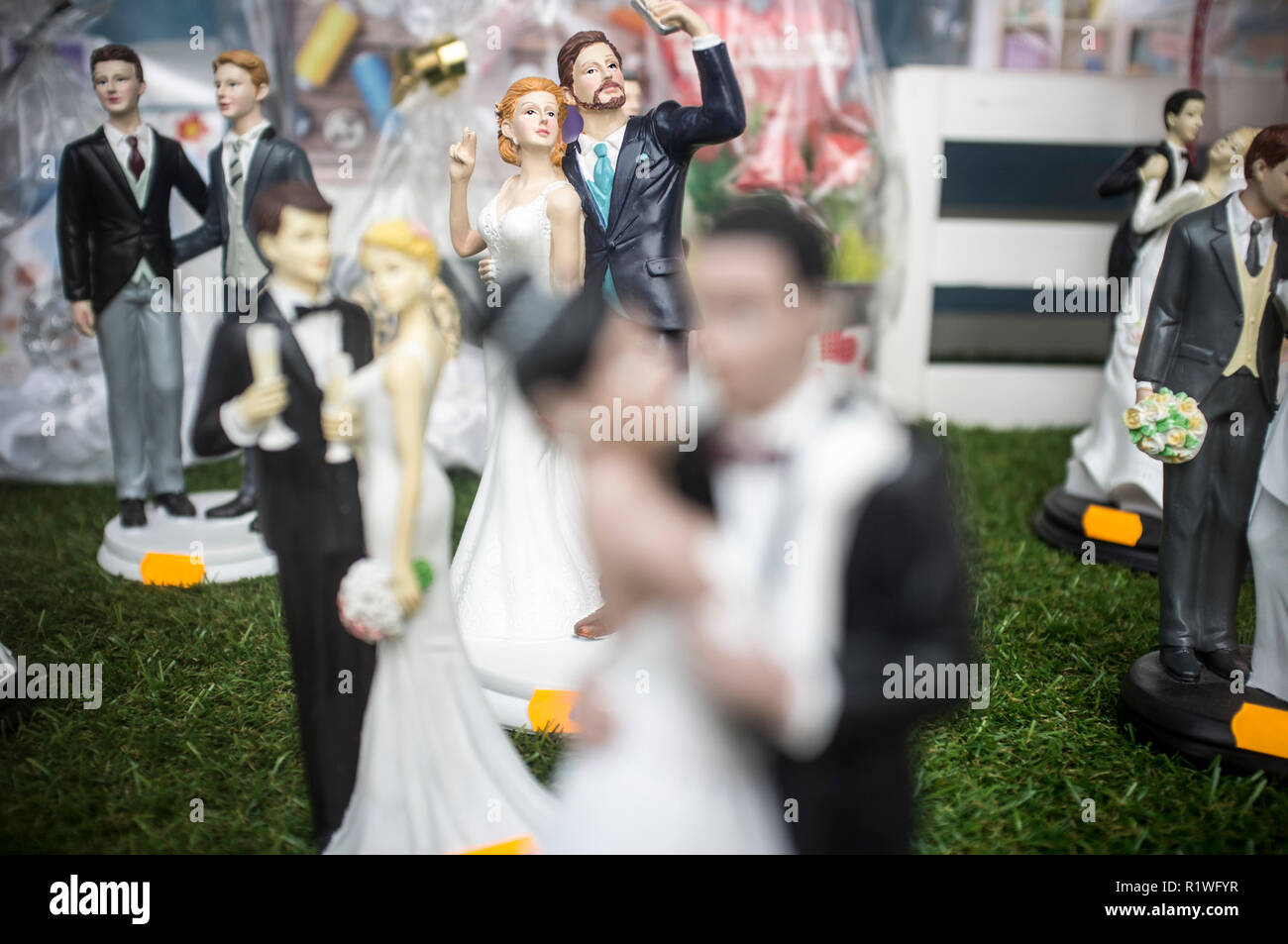 Badajoz, Spain - October 10th, 2018: Wedding cake figurines with a brides and bride. Couple taking selfies in focus Stock Photo