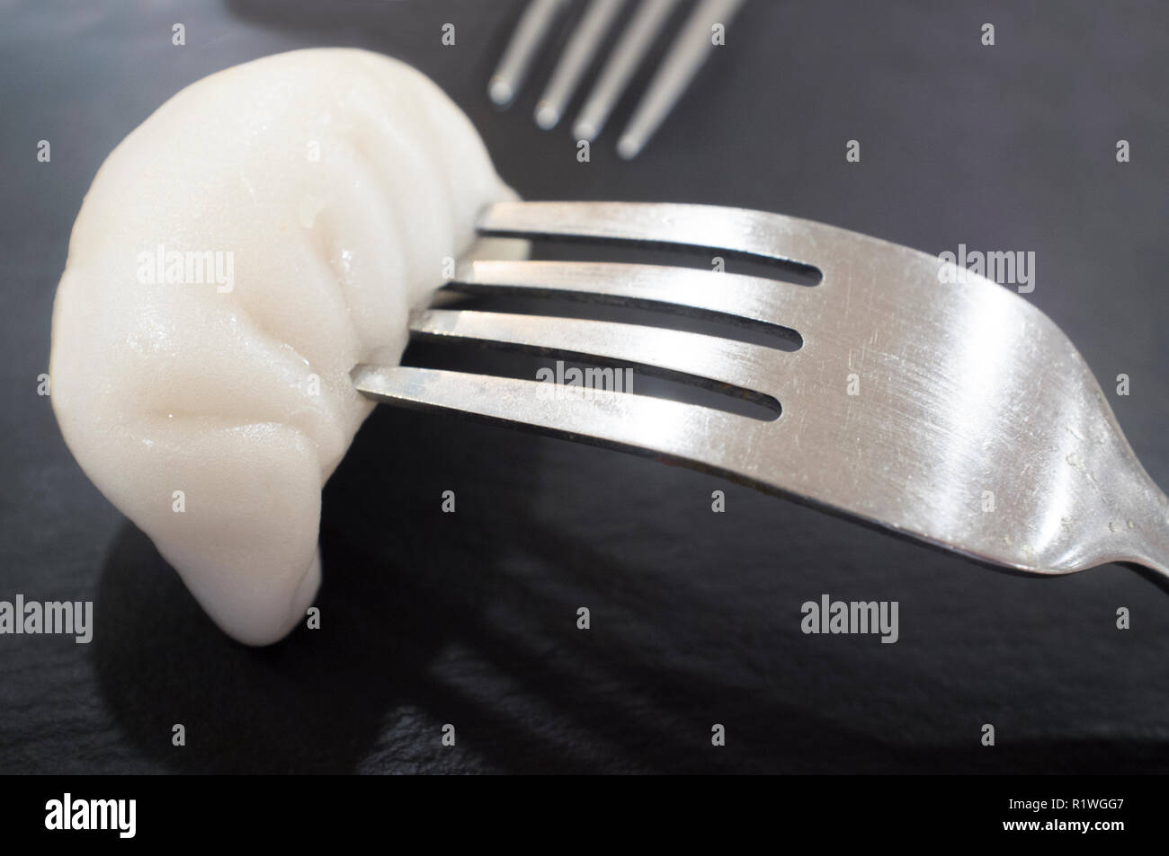 Steam dumpling Xia Jiao between forks. Closeup Stock Photo