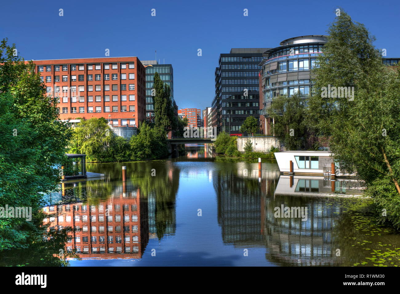 modern office architecture with reflections in the canals of Hamburg Stock Photo