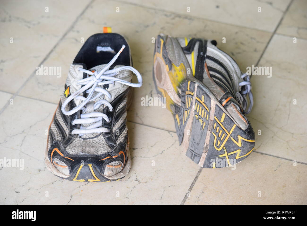 Pair of old Run and walking shoes worn out and with holes under the sole. Paar alte Lauf- und Wanderschuhe abgenutzt und mit Löchern unter der Sohle Stock Photo