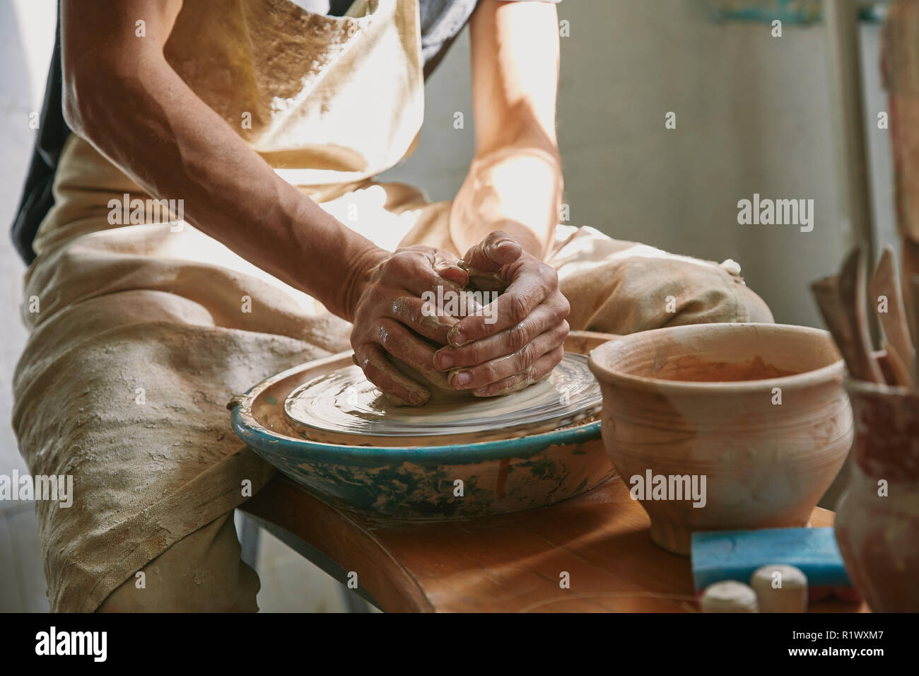 partial view of potter working on pottery wheel at workshop Stock Photo