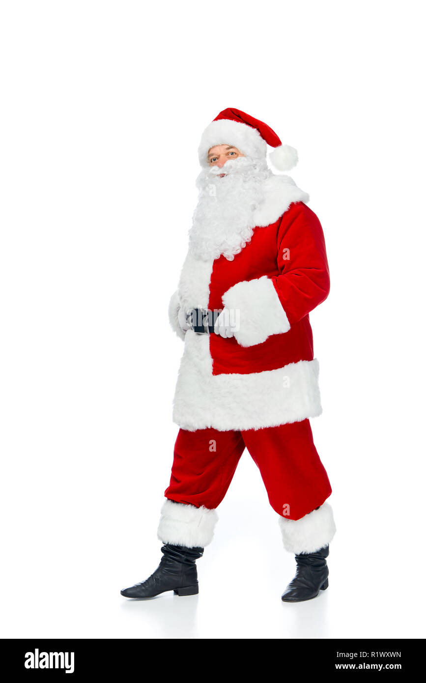 bearded santa claus walking in red costume at christmastime isolated on white Stock Photo