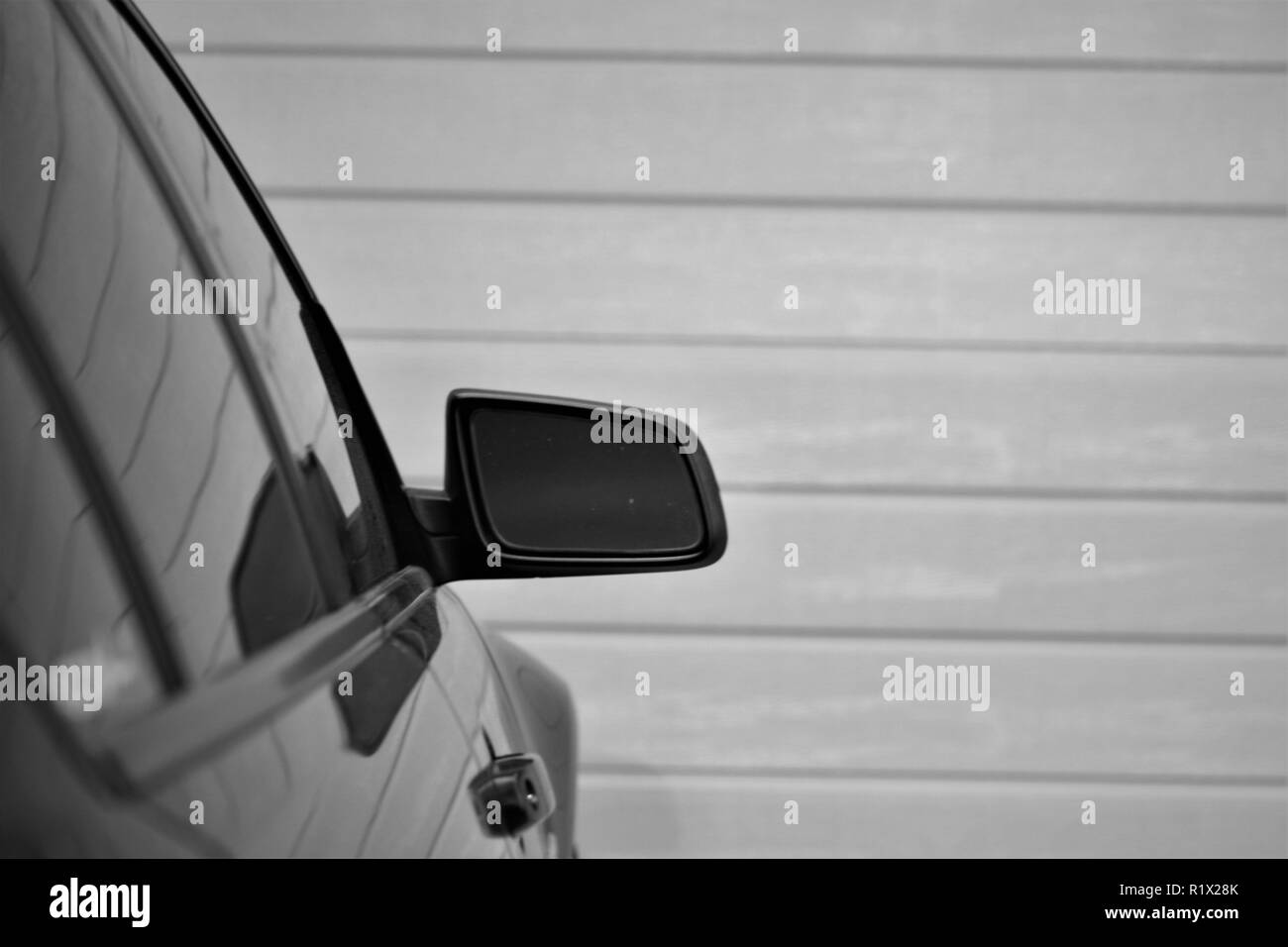 Black and white car mirror in driveway Stock Photo