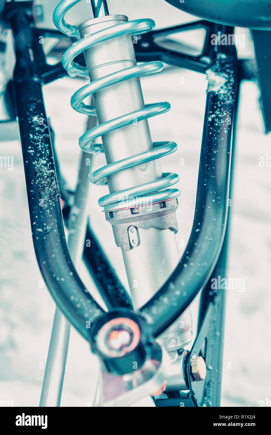 Detail of snowmobile suspension, shock absorber and spring in winter Finland, Rovaniemi, Lapland
