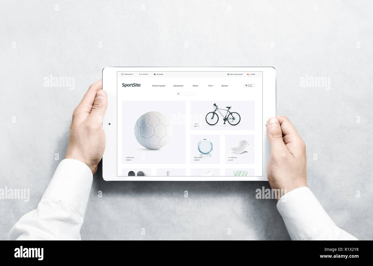 Hands holding tablet with sport webstore mock up on screen, isolated. Training web page interface mockup. Internet website template. Web store screen layout for computer display. Stock Photo