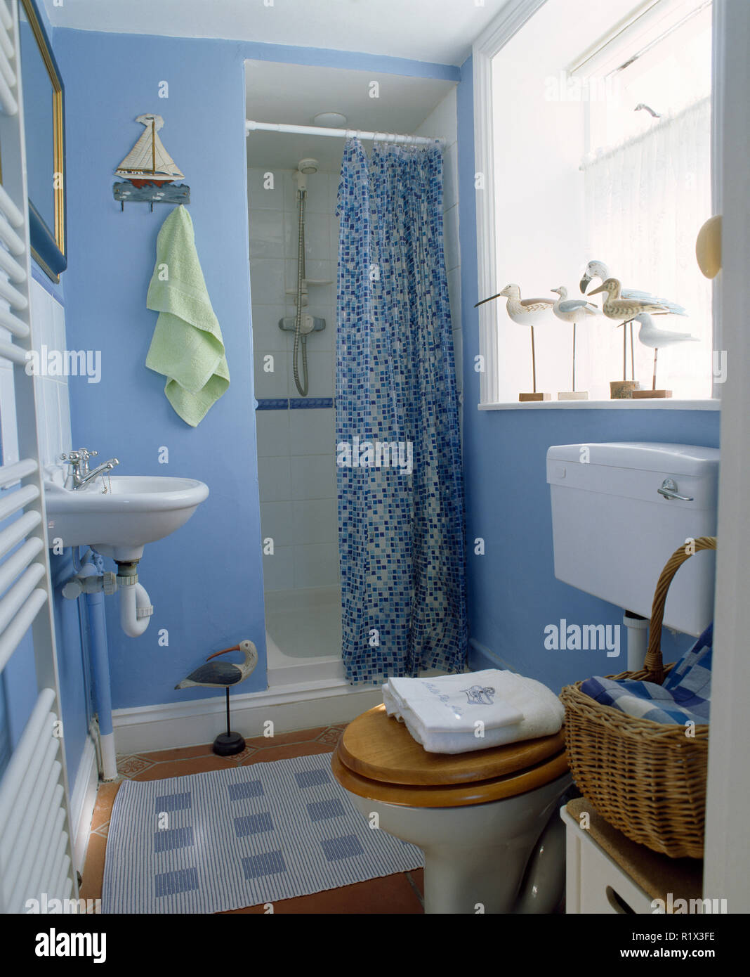 Blue bathroom with patterned curtain on shower recess Stock Photo
