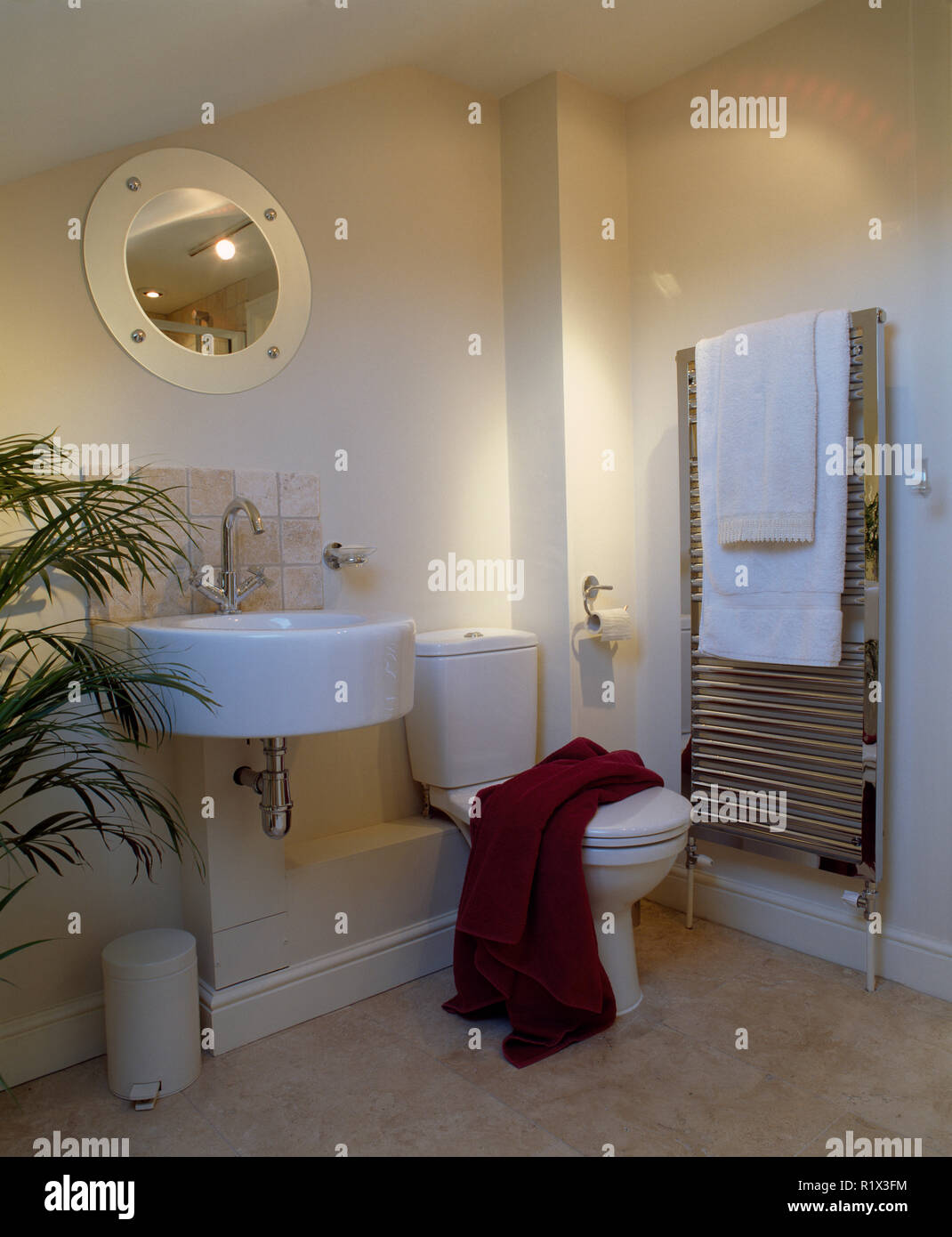 Circular basin in modern bathroom with heated towel rail Stock Photo
