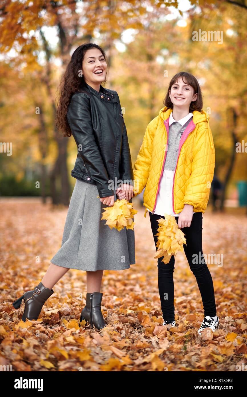 Two girls are in autumn city park Stock Photo - Alamy