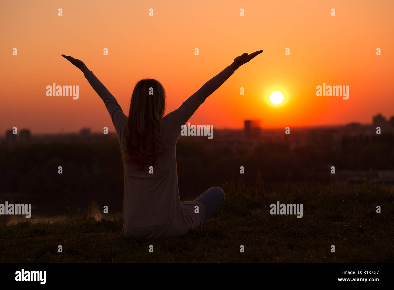 Silhouette of a woman meditating at the sunset Stock Photo - Alamy