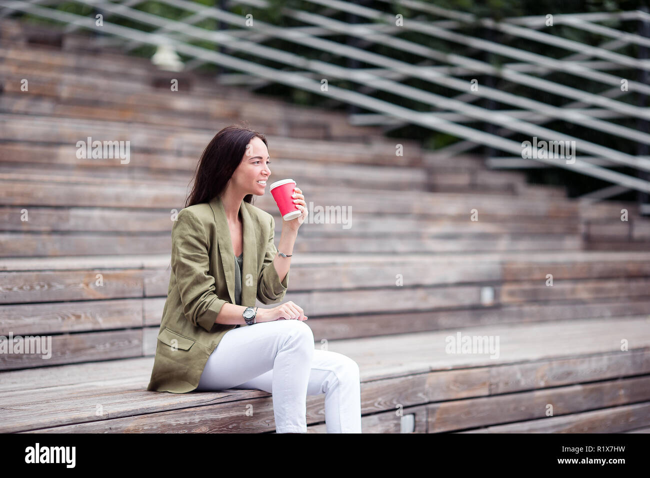 Woman drinking tasty coffee outdoors in the park Stock Photo