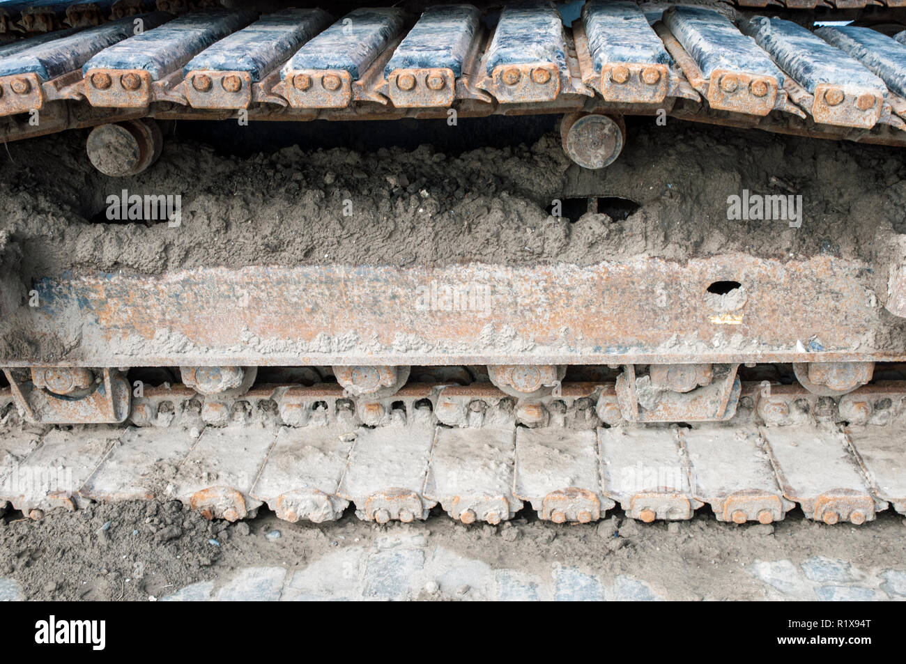 Close up of a set of synthetic rubber tracks on excavator whilst working on building site Stock Photo