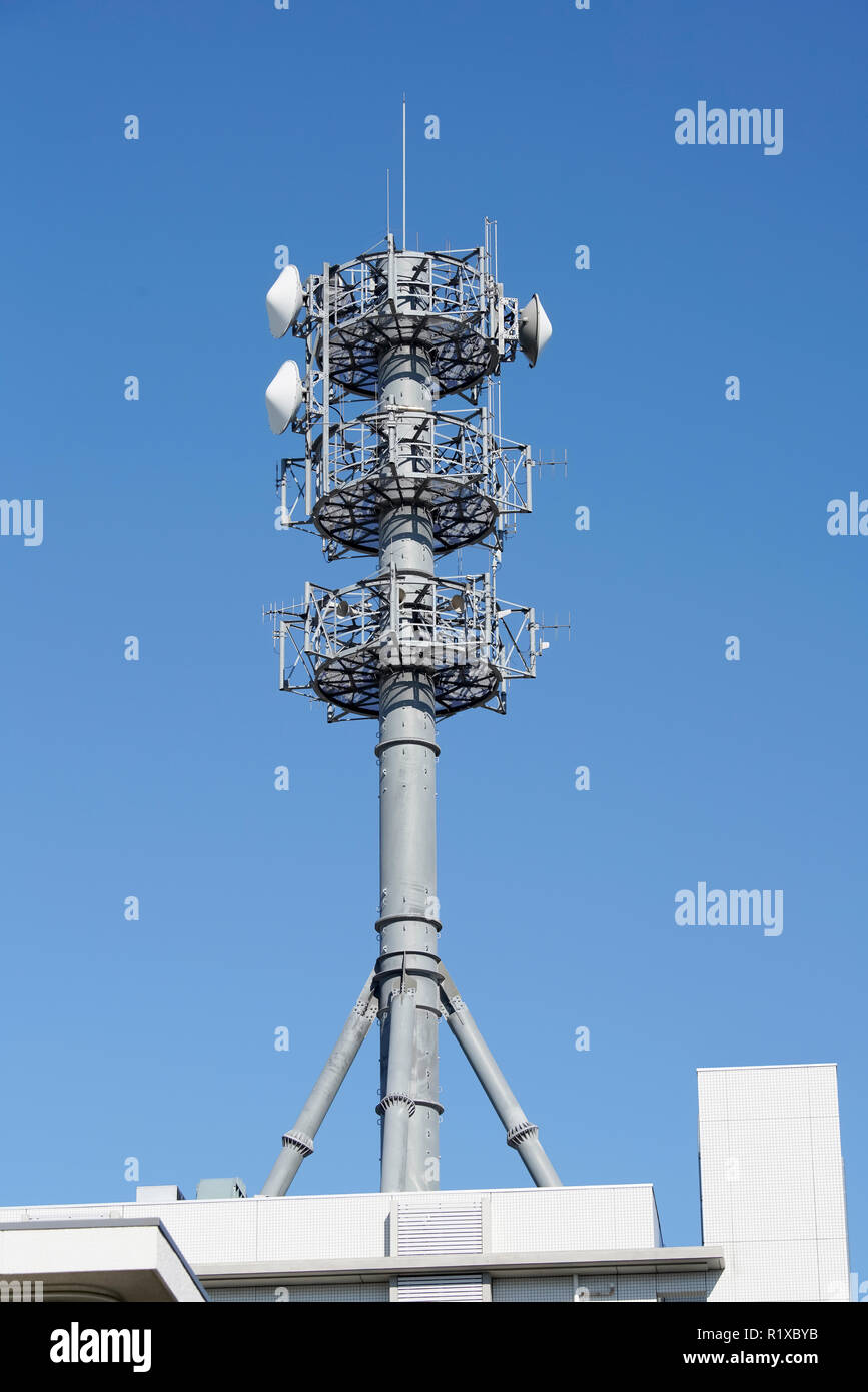 View of communication tower with antenna against blue sky Stock Photo