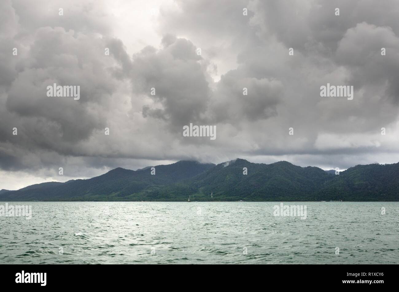 Landscape with tropical sea, monsoon storm heavy clouds and tropical Koh Chang island on horizon in Thailand Stock Photo